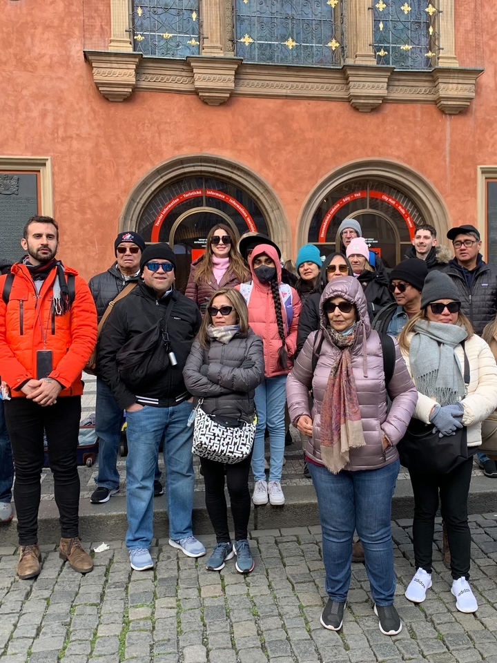 A group of people dressed warmly standing together in a city.