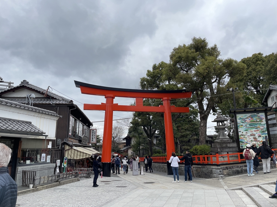 People walking under a large torii gate.