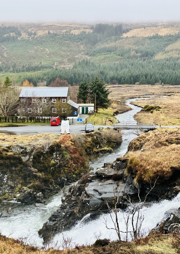 Landscape with a small river passing by a building in the countryside.