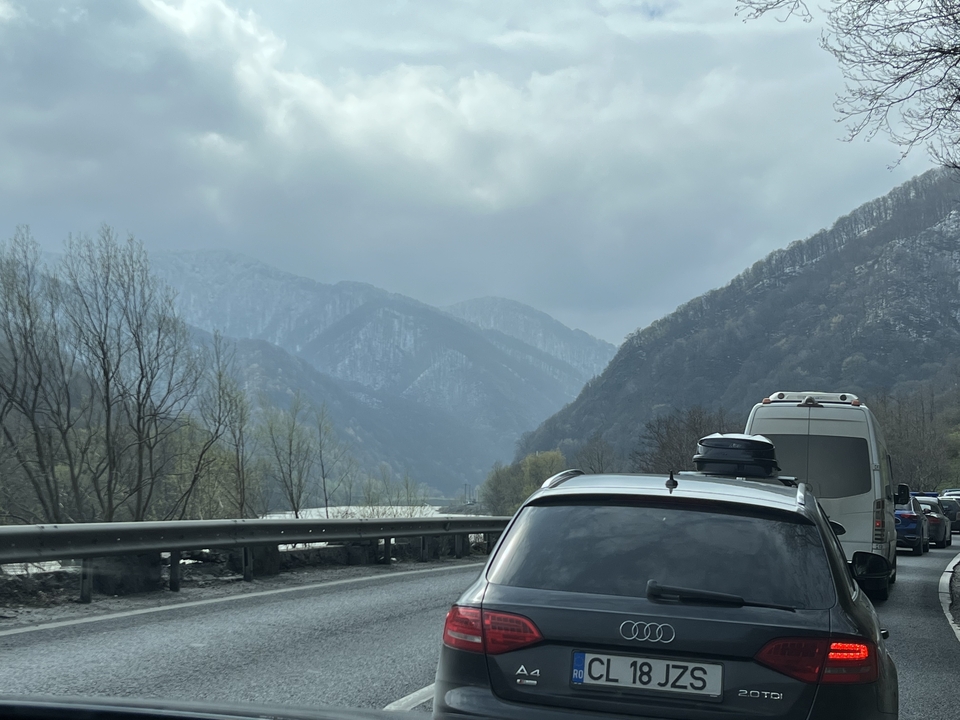 Mountain road with cars and snow-covered peaks.