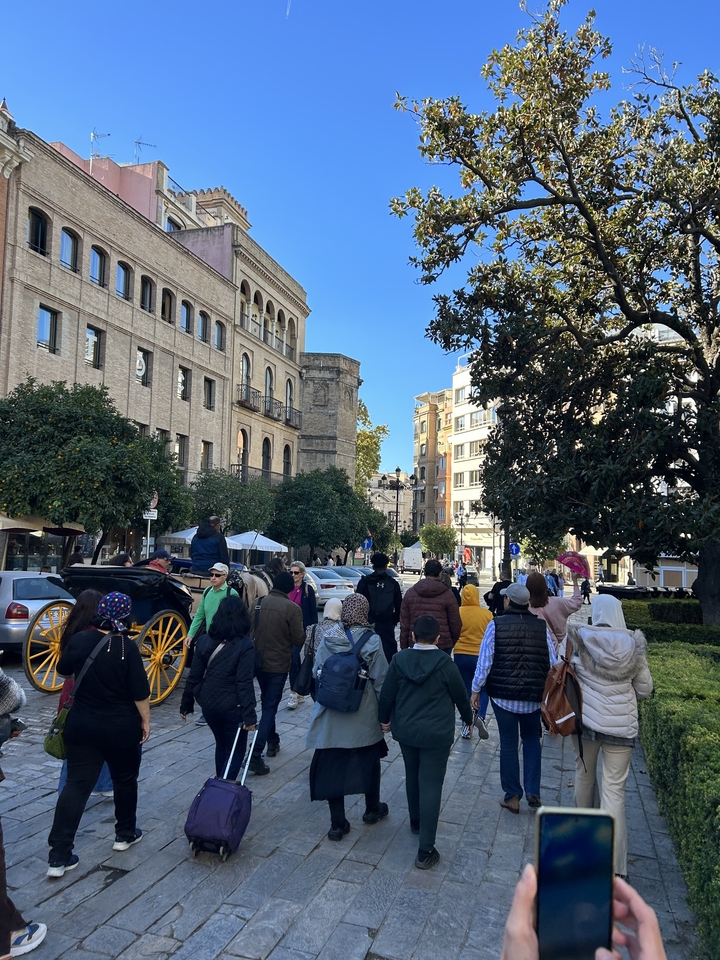Busy street scene with people and a horse carriage.