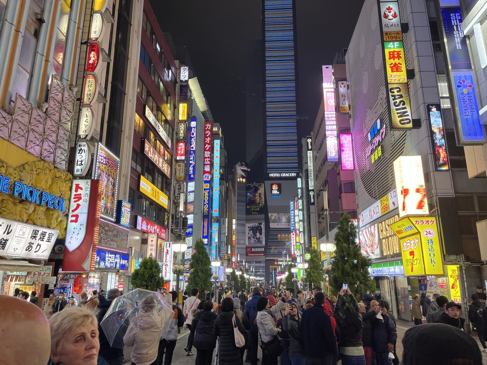 Rue animée de la ville la nuit avec des néons éclatants.