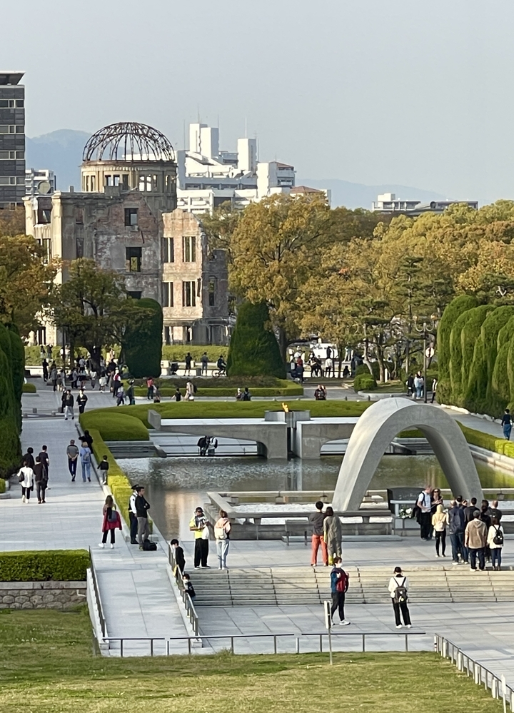 Parc du Mémorial de la Paix avec des arbres et une arche en béton.