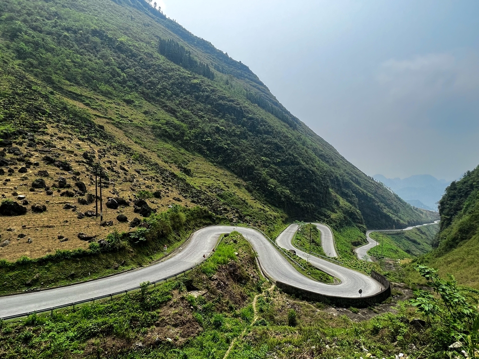 Winding road through hilly terrain with a motorbike.
