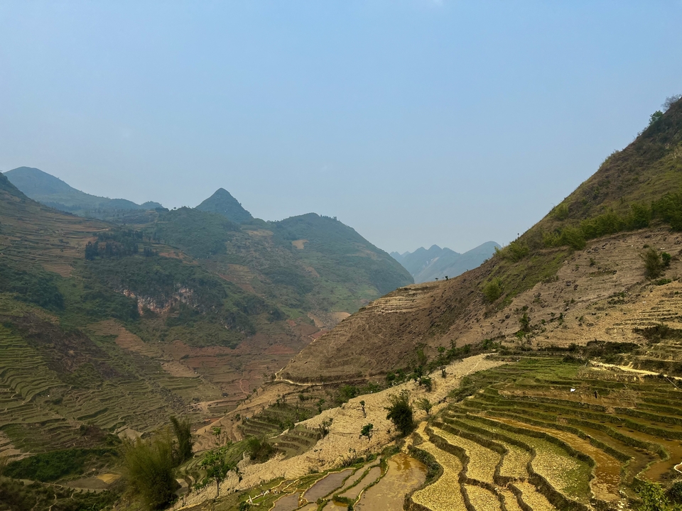 Fields and terraces with distant mountains.