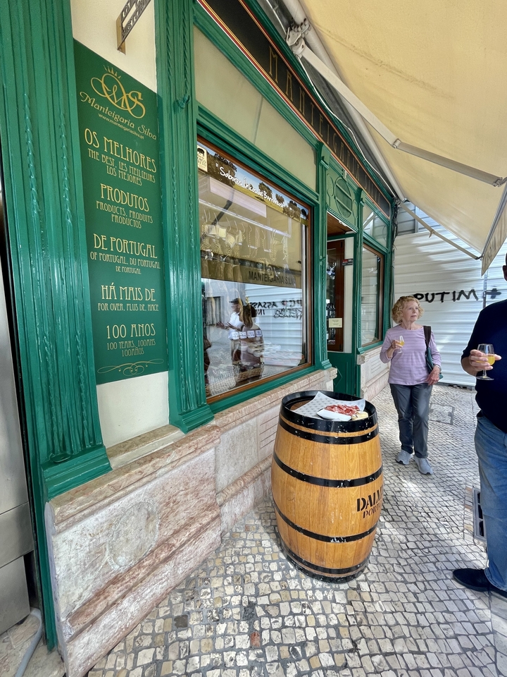 A woman standing outside a shop with a drink.