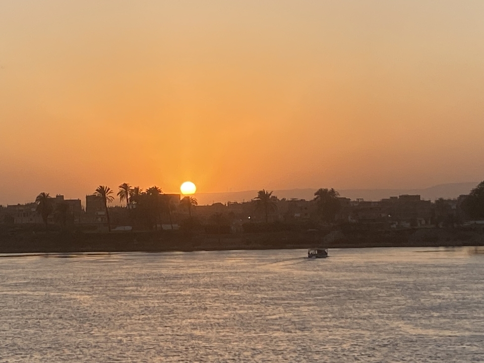 Sunset over a river with silhouette of trees