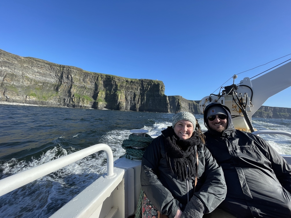 Deux personnes sur un bateau avec des falaises en arrière-plan.