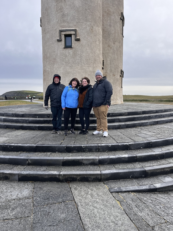 Groupe de personnes posant devant une structure de tour.