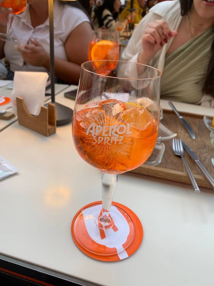 Close-up of a glass of Aperol Spritz on a table.