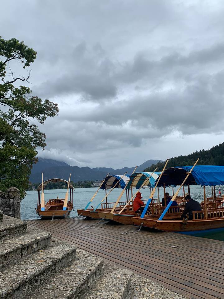 Boats docked by a lakeside with cloudy skies.