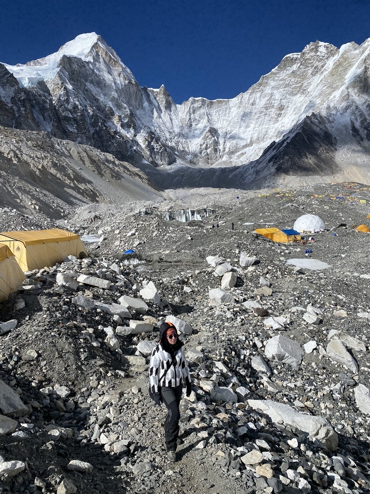 Hiker at Everest Base Camp with mountains.