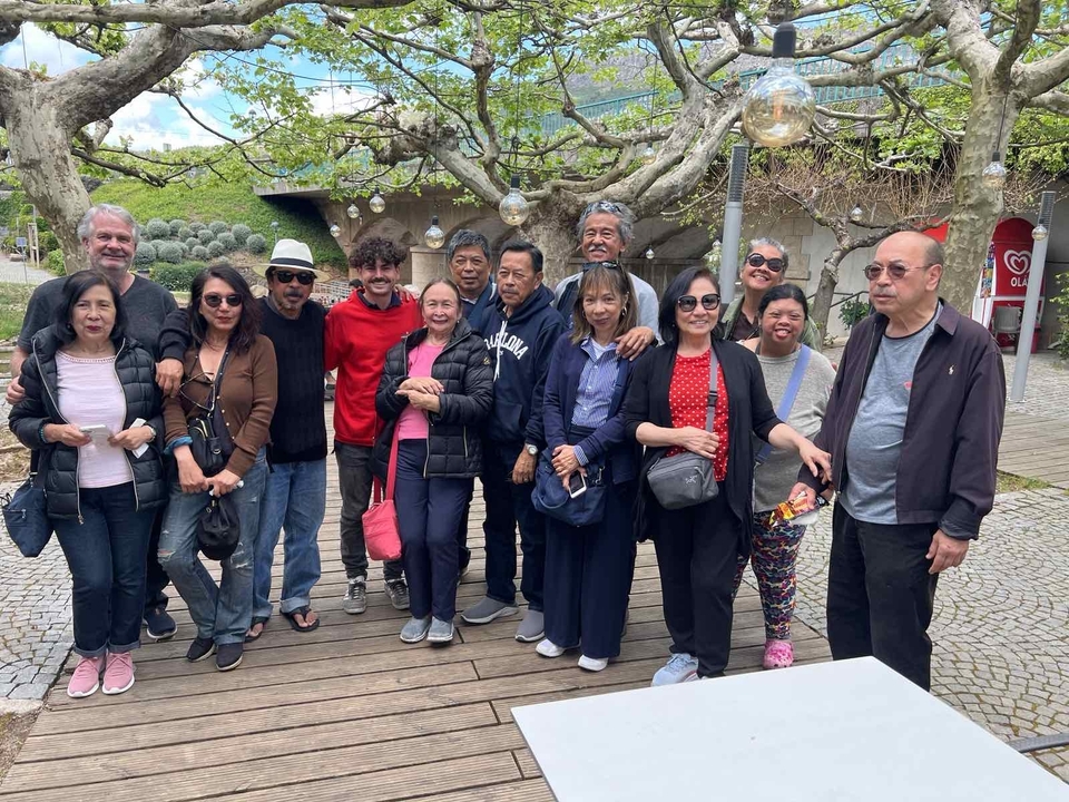 A large group of people posing together outdoors.