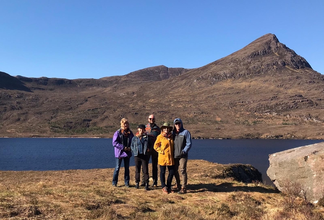 Groupe de personnes posant devant un paysage montagneux pittoresque