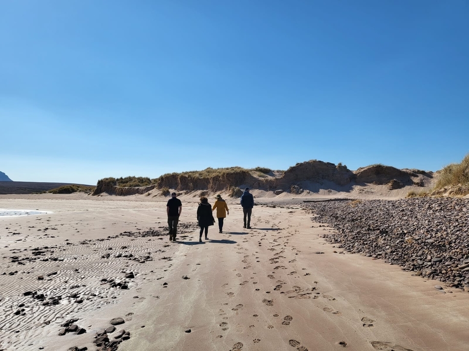 Groupe de personnes marchant le long d'une plage désolée