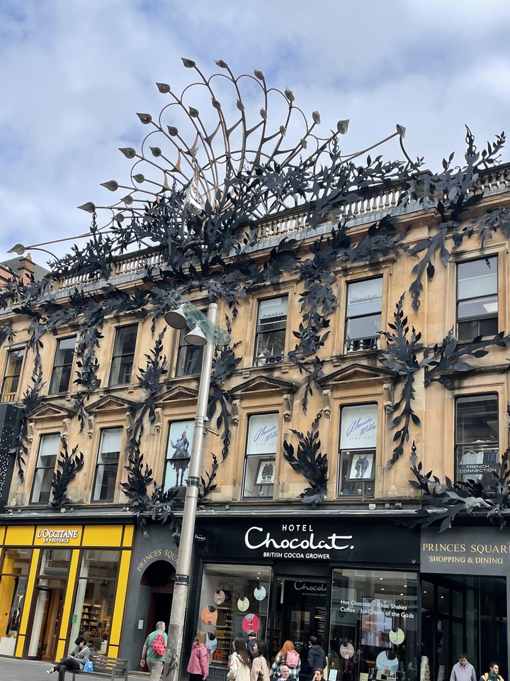 Storefront with decorated facade and metal leaf design.