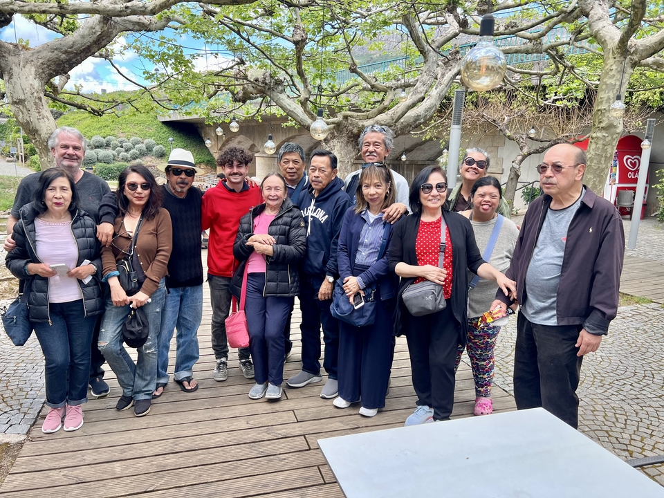 Large group of people posing together outdoors.