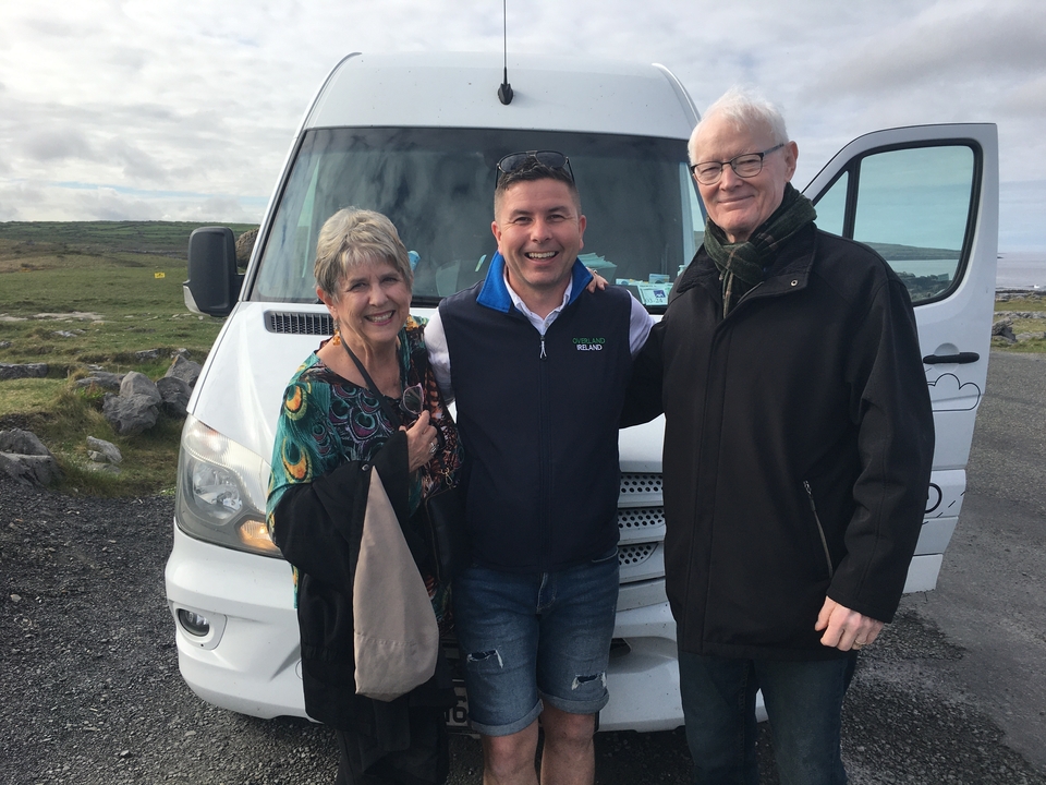 Trois personnes posant devant un van touristique.