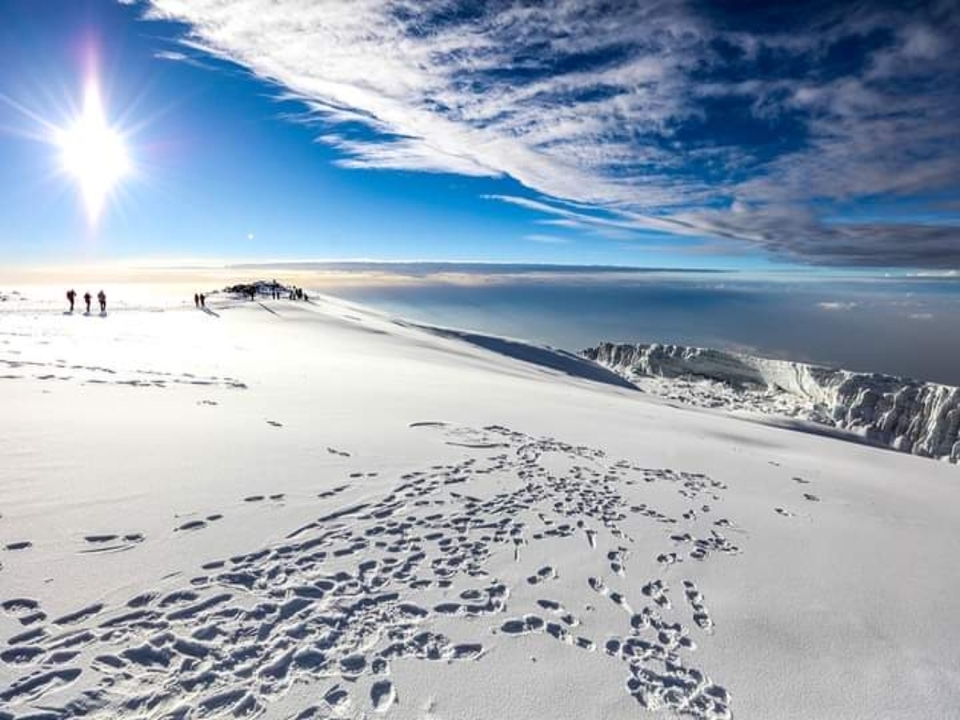 Montagnes enneigées sous un ciel lumineux.