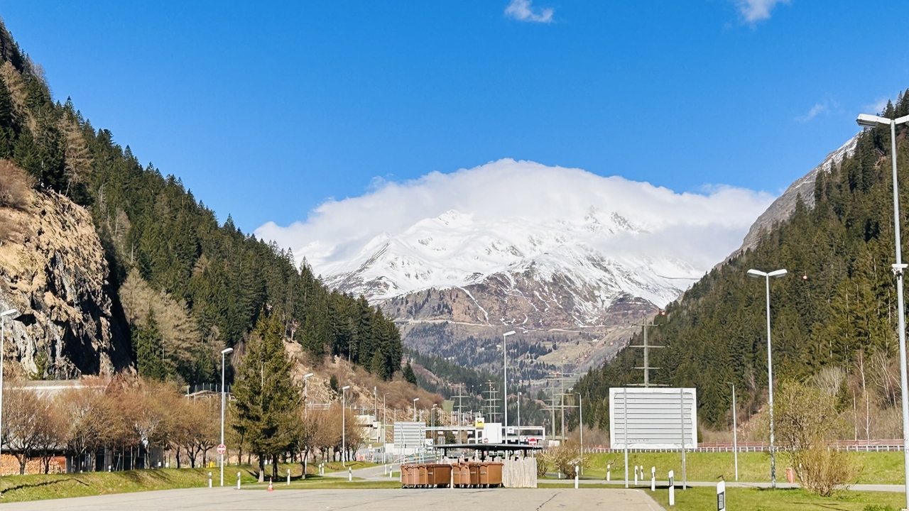 Scenic mountain landscape with snow-covered peaks and a road.