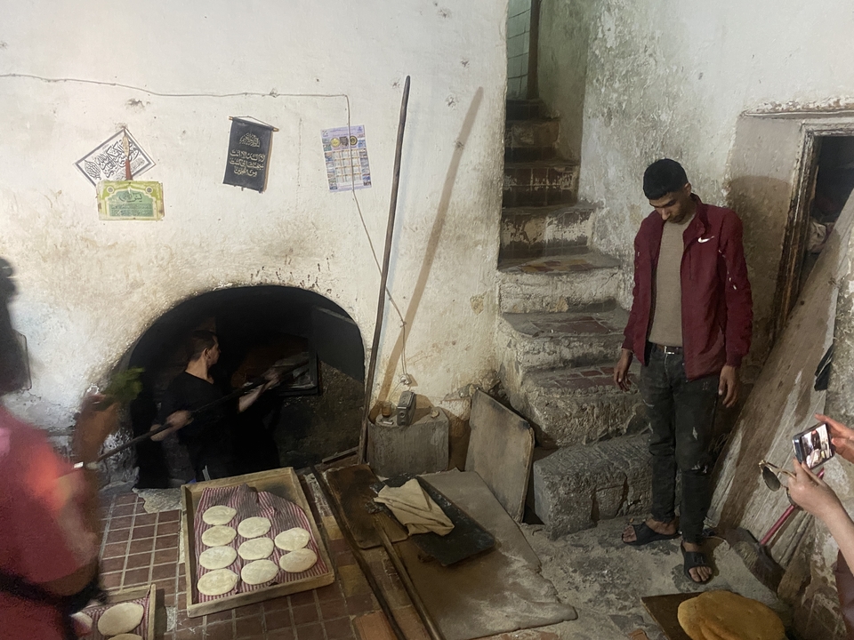 Traditional bakery with people observing the process.