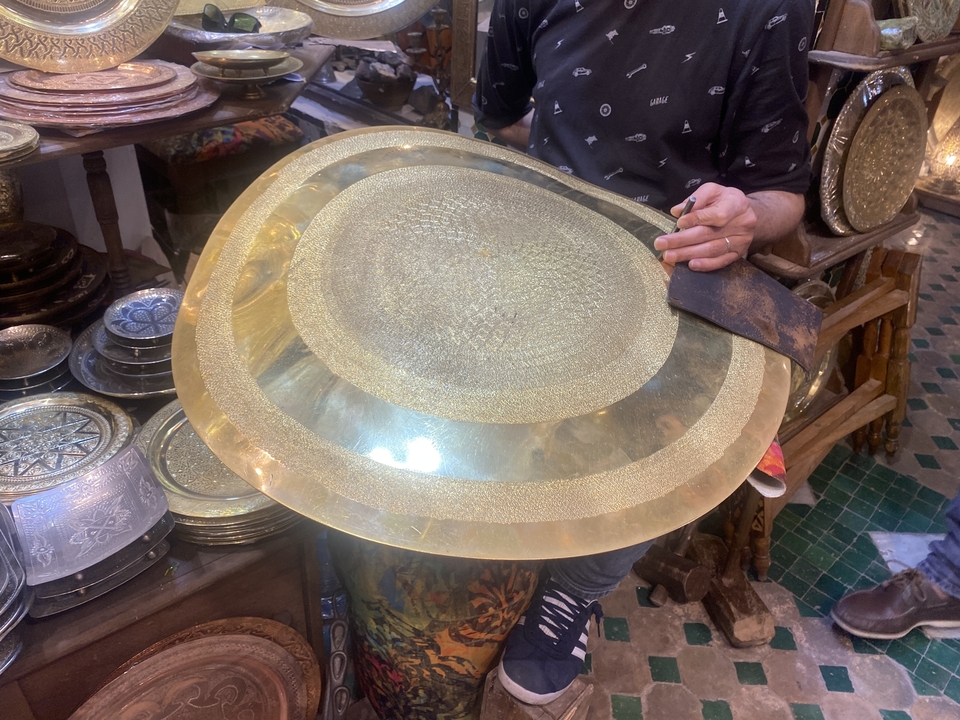 Person holding intricate metalwork item.