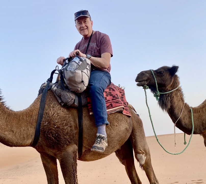 Person riding a camel in a desert landscape.