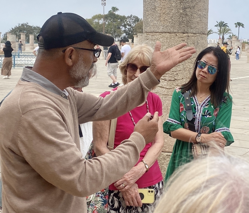 Group of people listening to a guide in a historic setting.