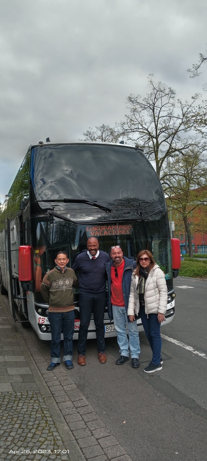 Des personnes posant devant un autocar de tourisme.