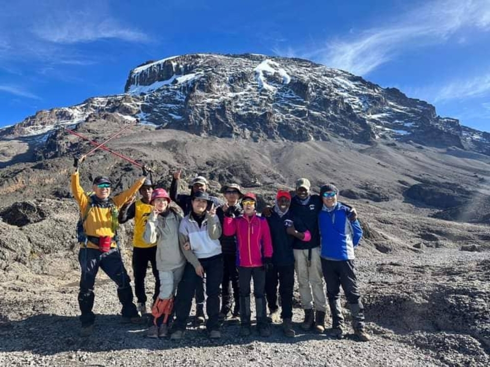 Groupe de grimpeurs avec le Kilimandjaro en arrière-plan.