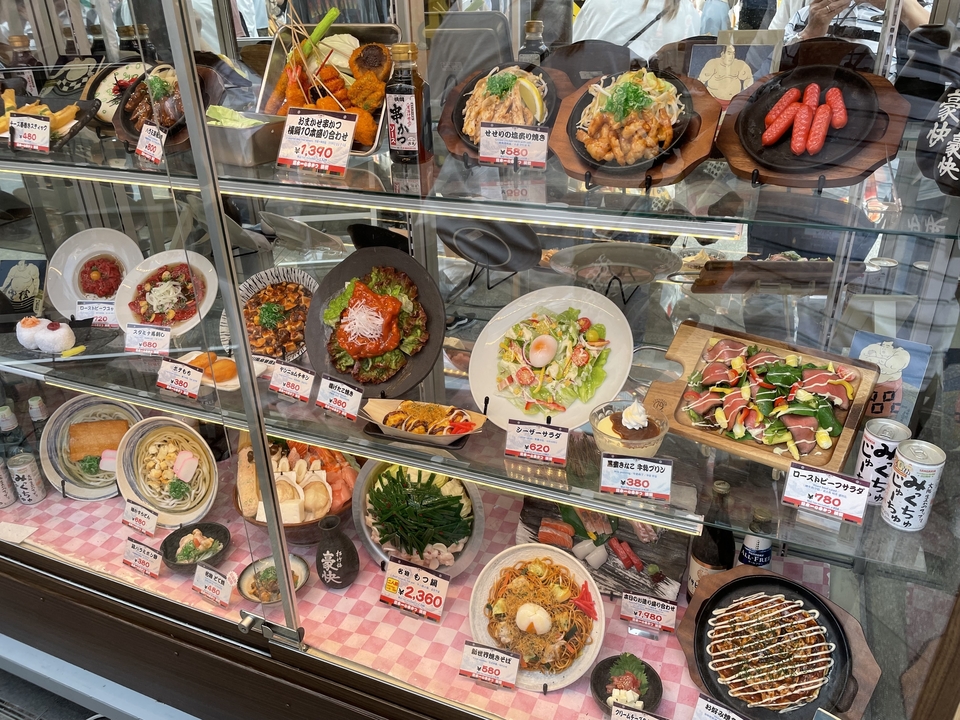 Window display with different plated dishes and prices.