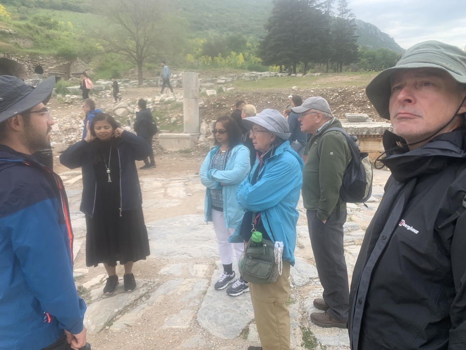 Group of tourists gathered outdoors at historical ruins.