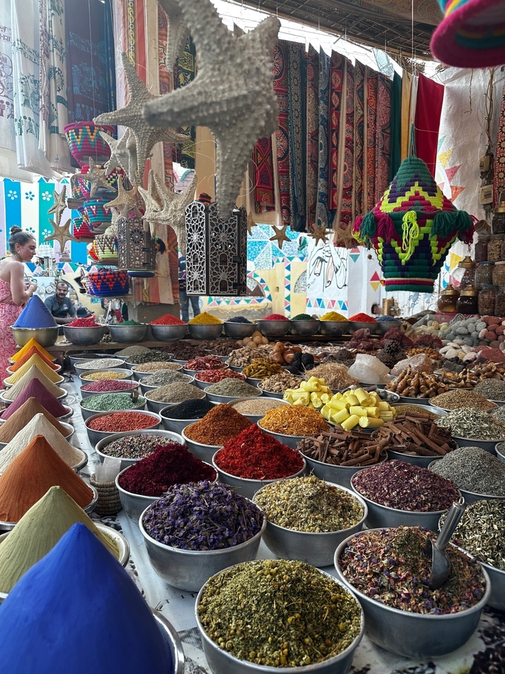 Market stall with various spices displayed in bowls.