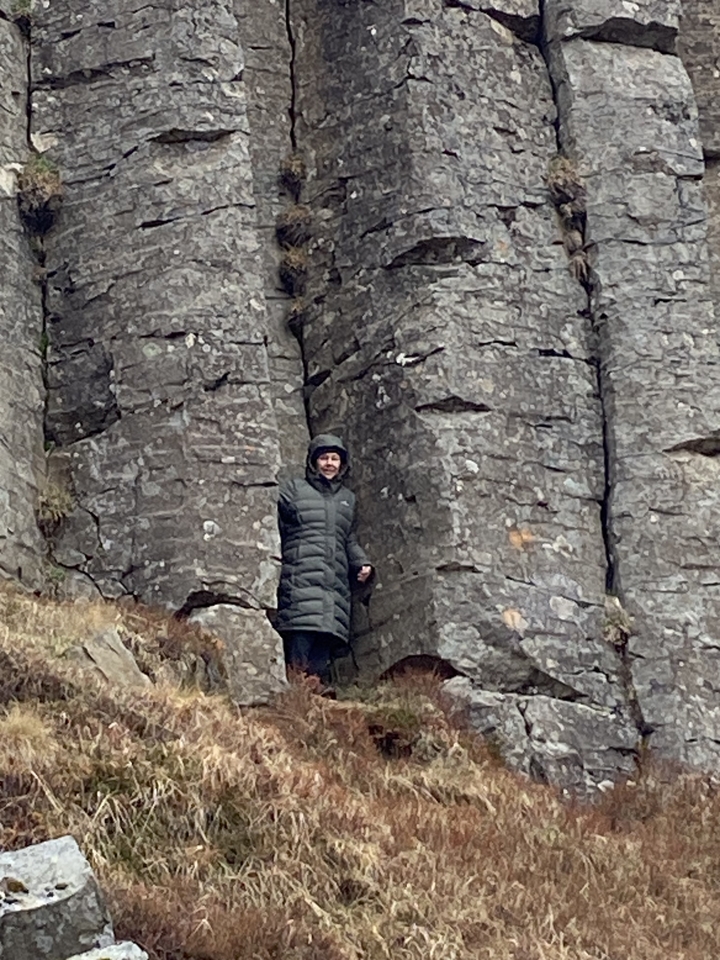 Une personne en vêtements d'hiver se tenant parmi des formations rocheuses.