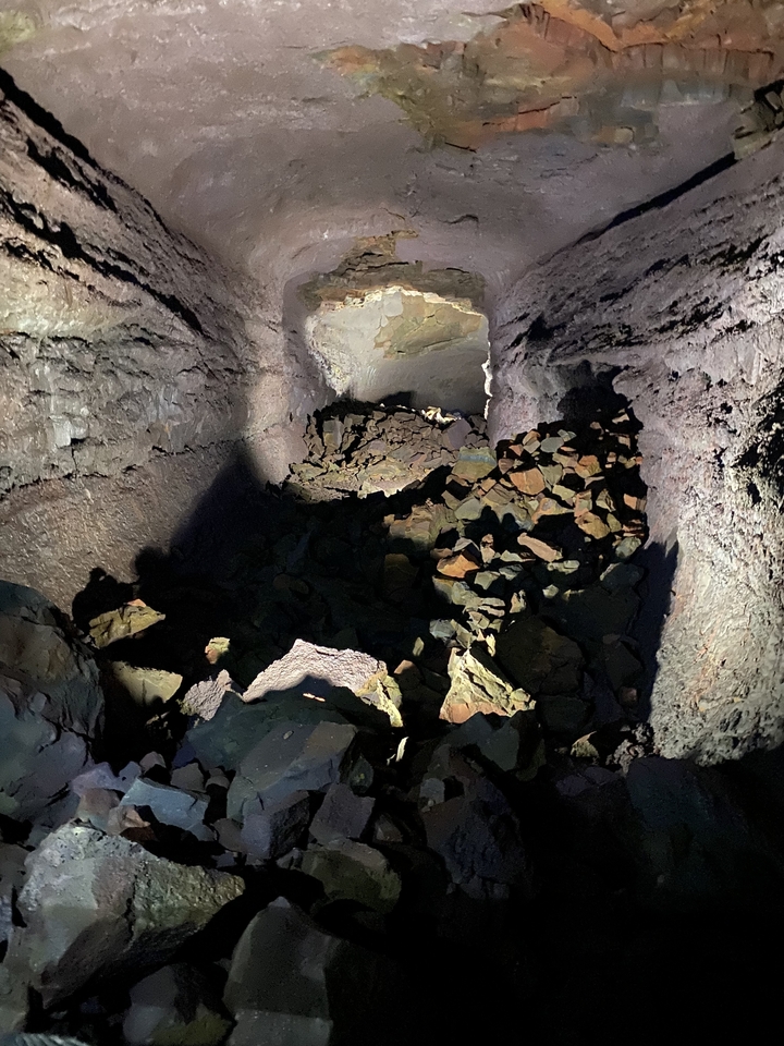 Dans une grotte sombre avec un intérieur rocheux et des ombres.