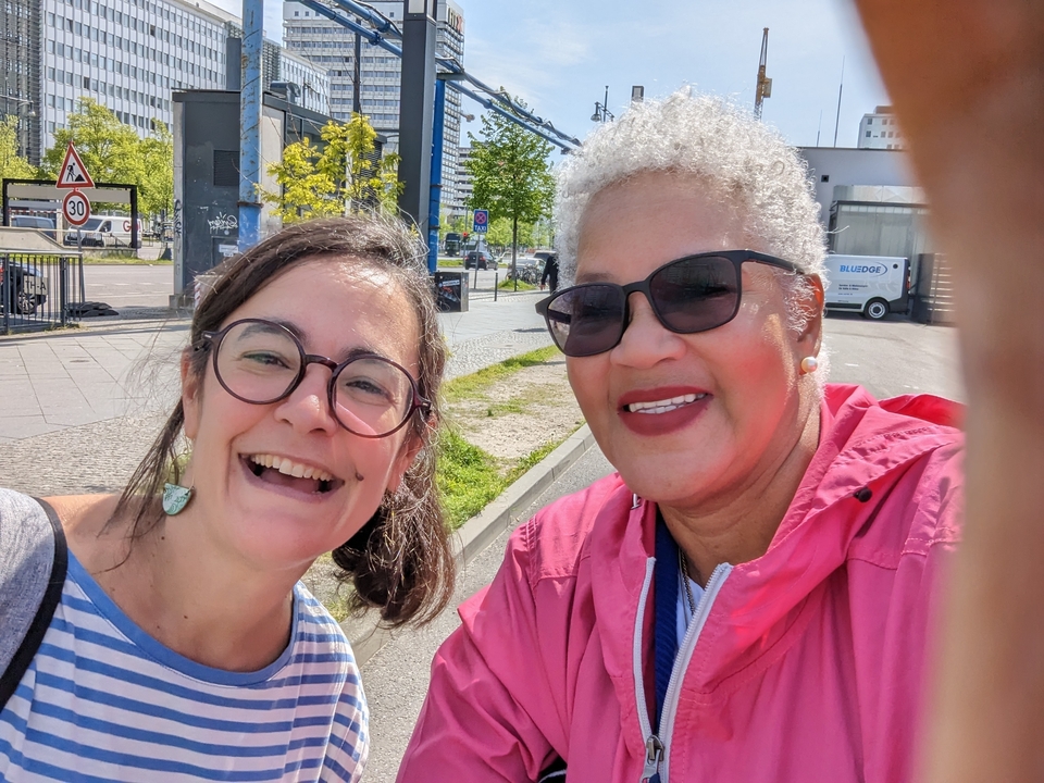 Deux femmes posant pour un selfie ensemble dans un espace extérieur ensoleillé.