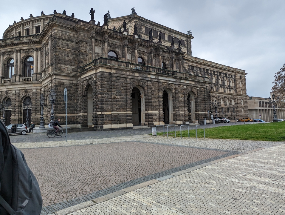 Façade de bâtiment en pierre avec fenêtres cintrées dans une zone urbaine.