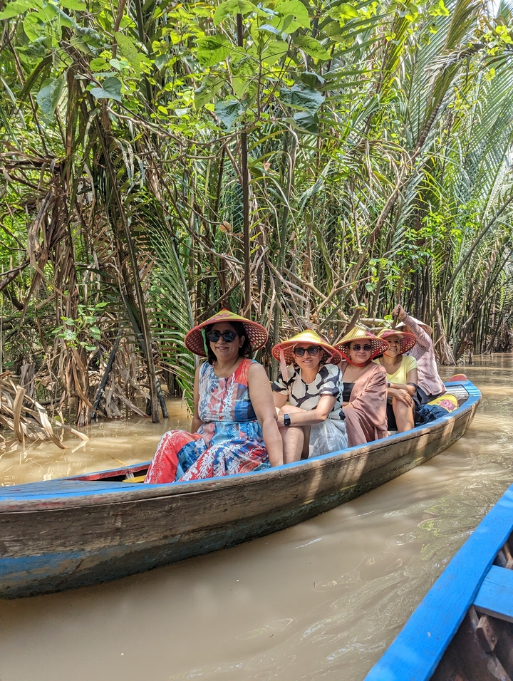 Group of tourists in a boat ride through lush greenery.