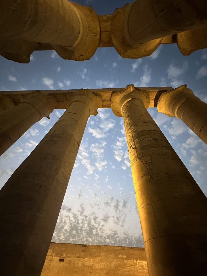 Dramatic angle of ancient columns against a blue sky.