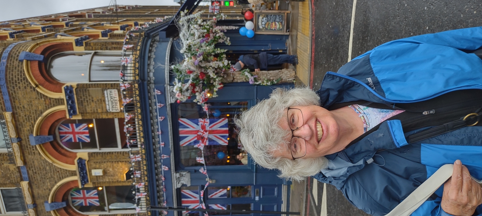 Personne souriante devant un pub décoré.