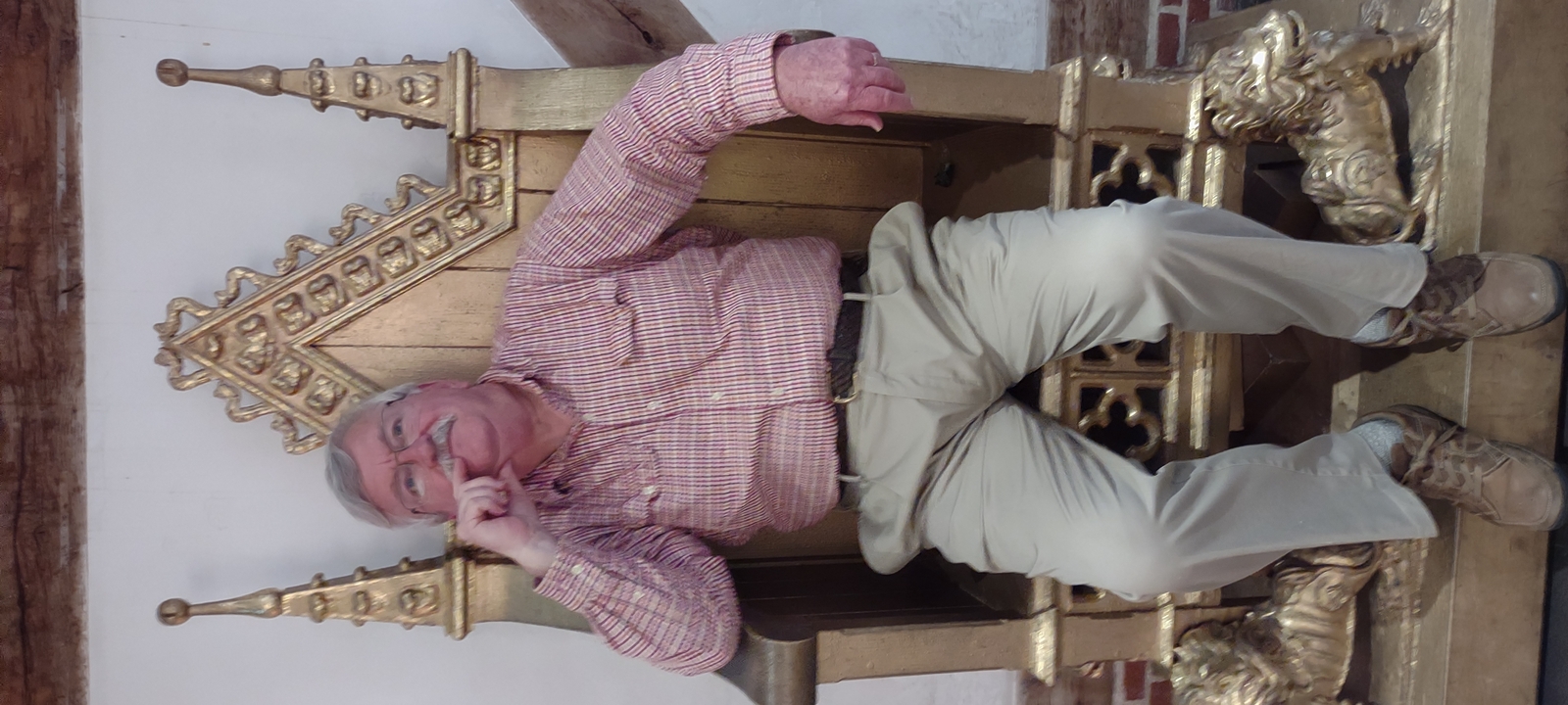 Personne assise sur un trône à l'intérieur.