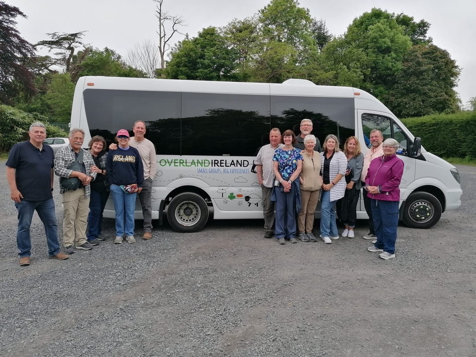A group of people standing in front of a tour bus.