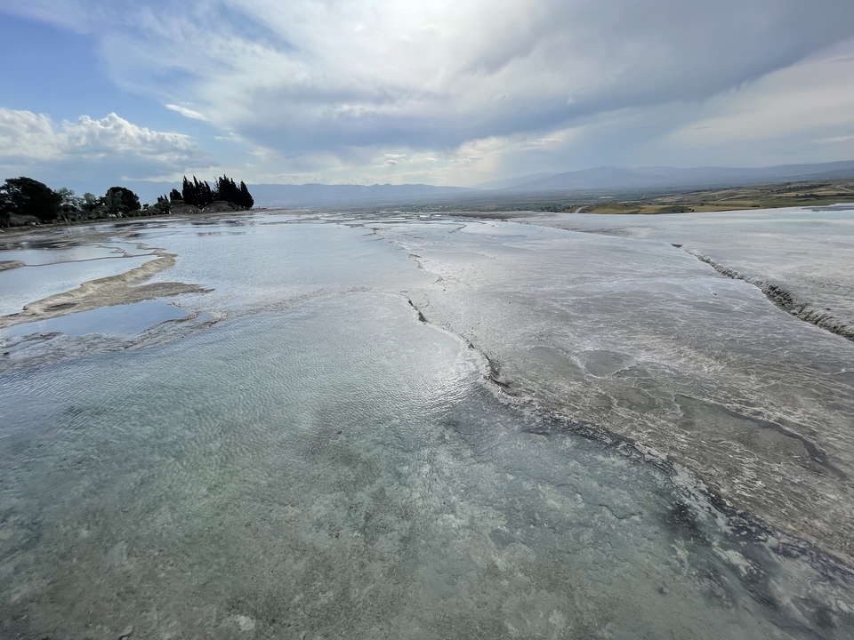 Pamukkale travertine terraces with water.