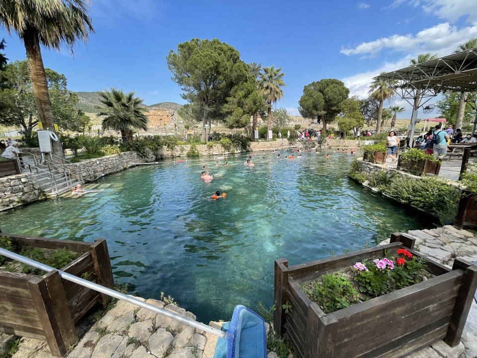 Natural thermal pool with people swimming.