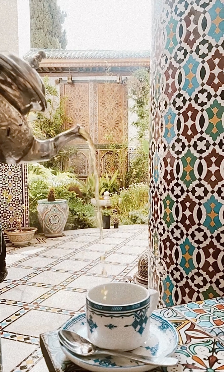 Intricate tile work and a decorative pot in a tranquil courtyard.