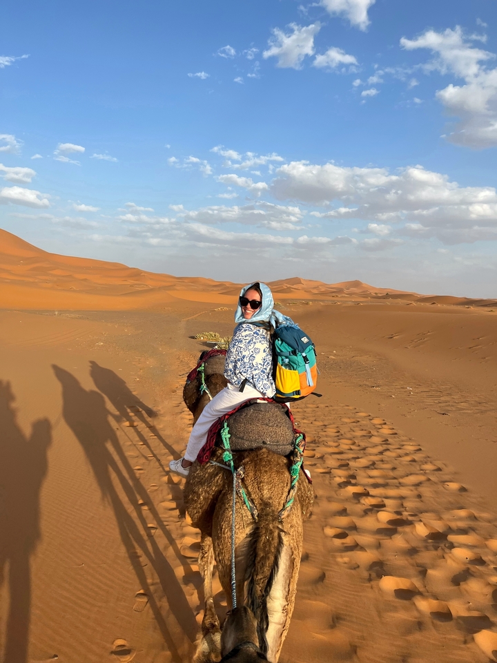 Woman riding a camel in the desert.