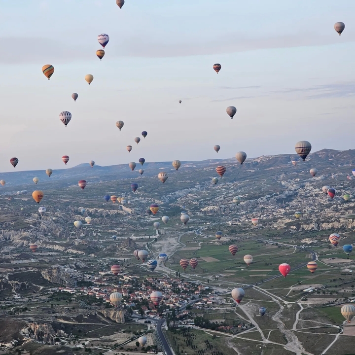 Montgolfières s'élevant au-dessus d'un paysage rocheux.