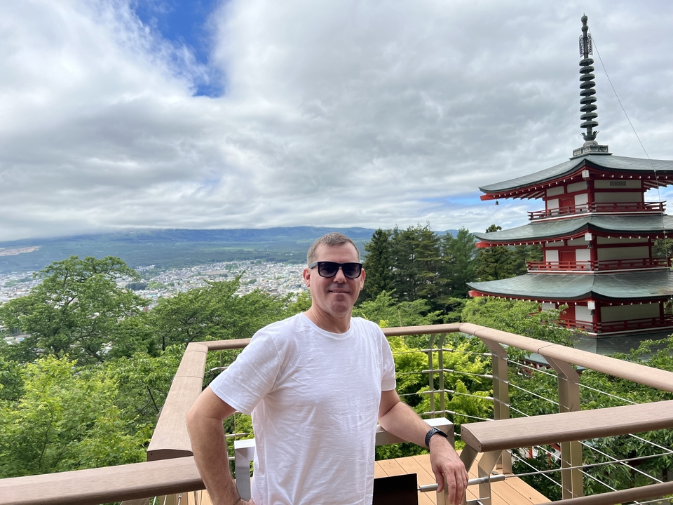 Personne debout sur une plateforme d'observation près d'une pagode.