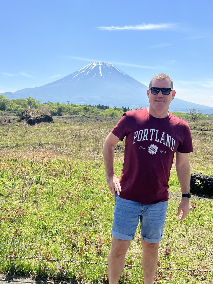 Personne sur un champ herbeux avec une montagne en arrière-plan.