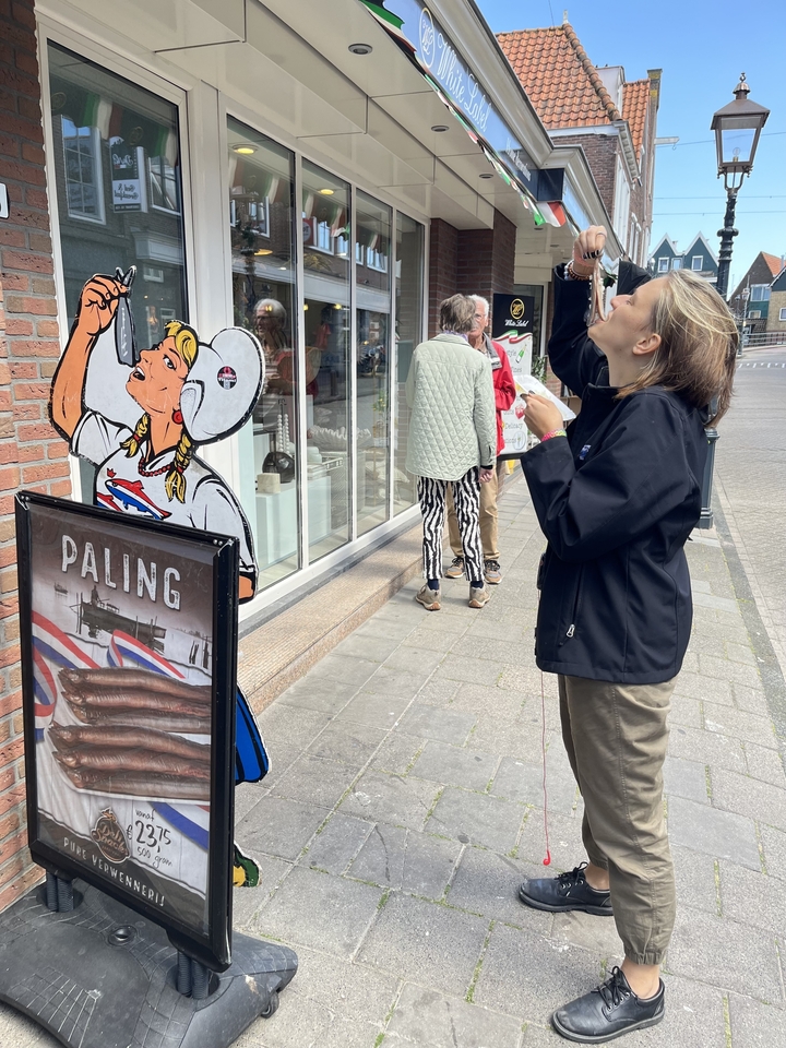 Personne prenant une photo près d'une vitrine avec des affiches de poissons.